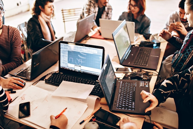 People on laptops sat around a desk